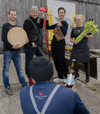 Bier vom Daberer Slow Food Lehre Produzenten-Partner LONCIUM auf der Schulter von Küchenlehrling James PAUL Im Bild (von links nach rechts): Lukas ZANKL (Produzenten-Partner Slow Food Lehre, Bio-Rohmilchkäser in Dellach im Gailtal) | Herwig ERTL (Edelgreissler, Obmann Slow Food Convivium Gail- & Lesachtal) | Marianne DABERER (Biohotel der daberer) | Magdalena LIEBERT (Küchenlehrling im Biohotel der daberer) (06) | Foto: der daberer/F. Neumüller