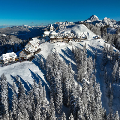 Der Monte Lussari - Postkartenidylle mit Wallfahrtskirche, Restaurants und Blick auf die Julischen Alpen direkt an der Skipiste